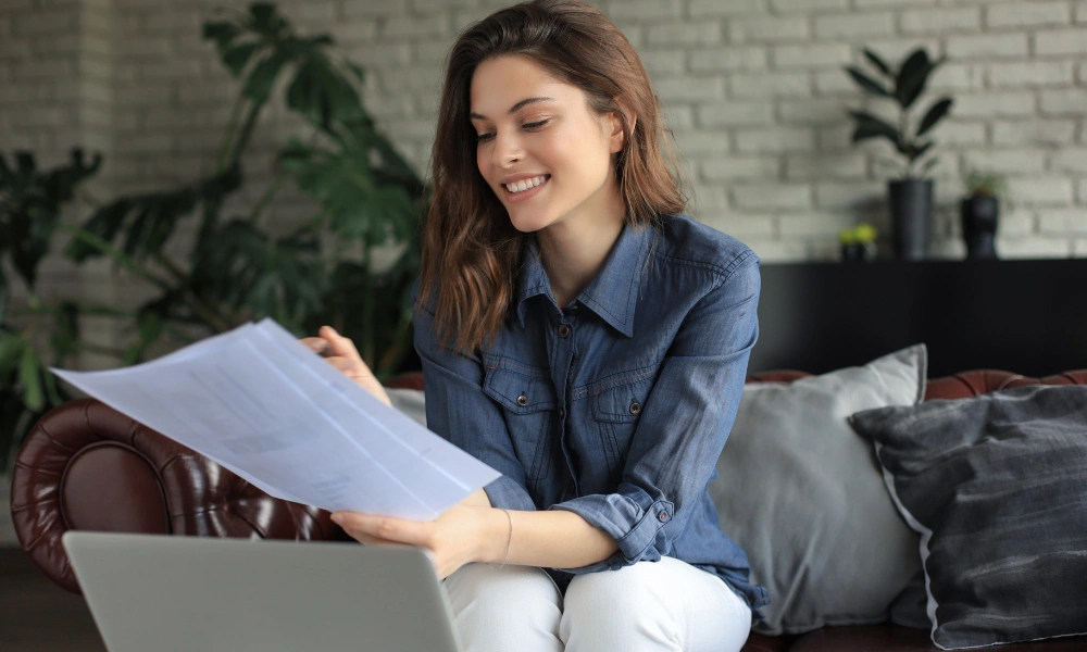 Emprendedora revisando documentos frente a su laptop para registro de empresas en Texas desde casa